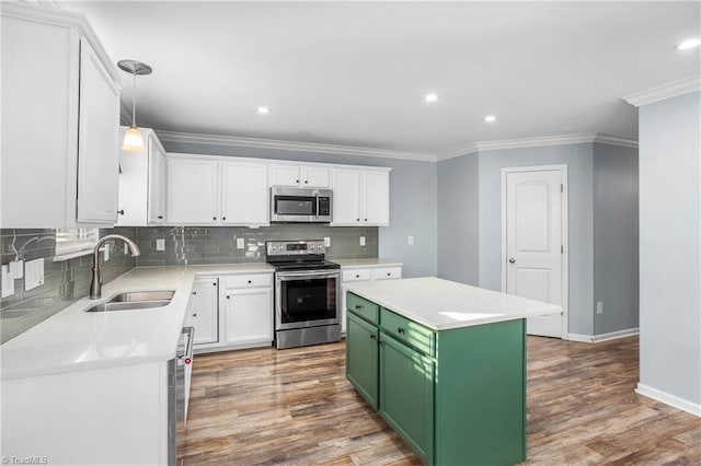 kitchen with appliances with stainless steel finishes, green cabinets, sink, a kitchen island, and white cabinets