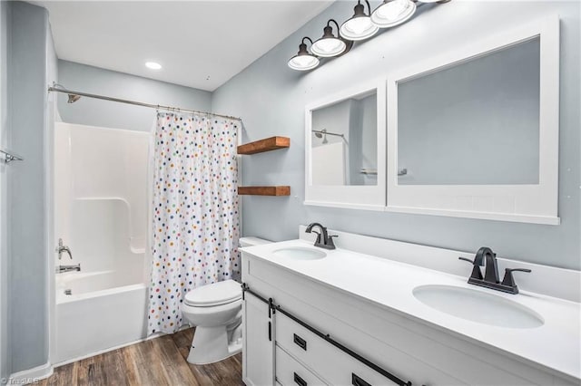 full bathroom featuring vanity, toilet, hardwood / wood-style floors, and shower / tub combo with curtain