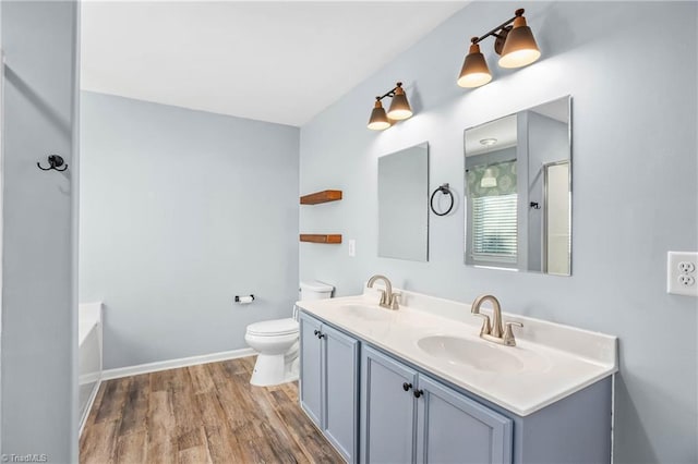 bathroom with vanity, hardwood / wood-style flooring, a bathtub, and toilet