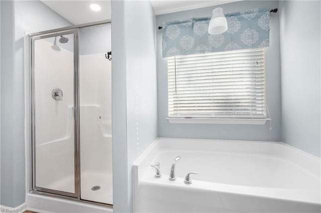 bathroom featuring shower with separate bathtub