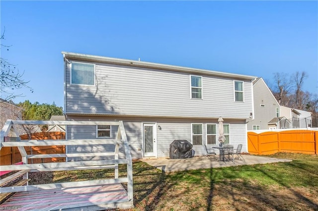 back of property with a patio area and a yard