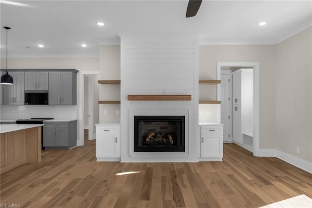 kitchen featuring open shelves, light wood-type flooring, gray cabinets, and decorative backsplash