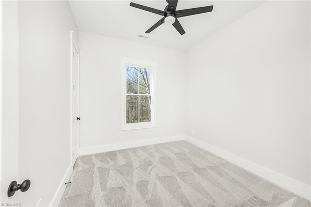 carpeted empty room featuring ceiling fan, visible vents, and baseboards