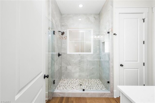 full bath with a shower stall, wood finished floors, and vanity