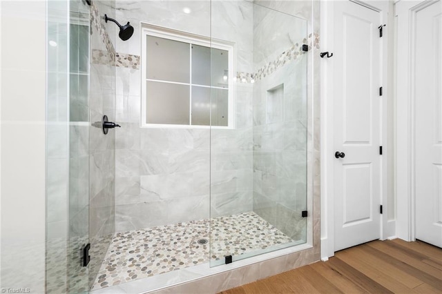 full bathroom featuring a stall shower and wood finished floors