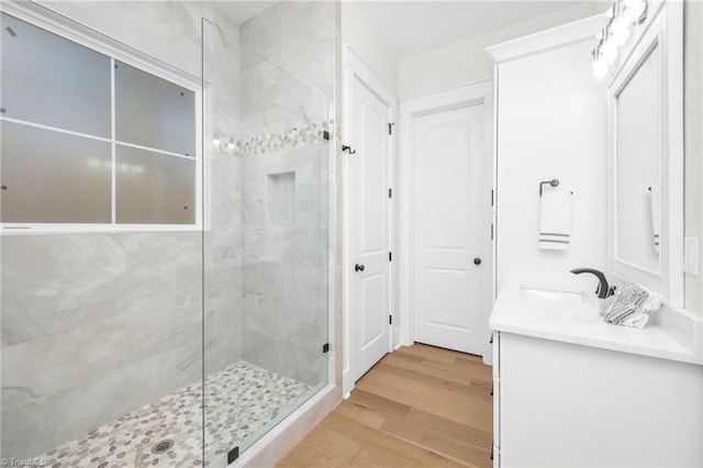 bathroom featuring a stall shower, wood finished floors, and vanity