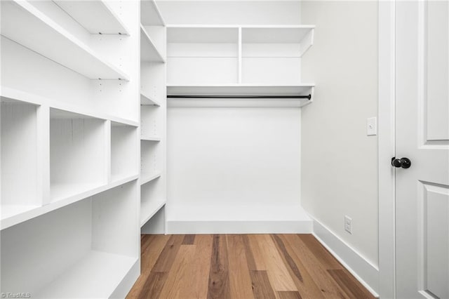 walk in closet with wood finished floors