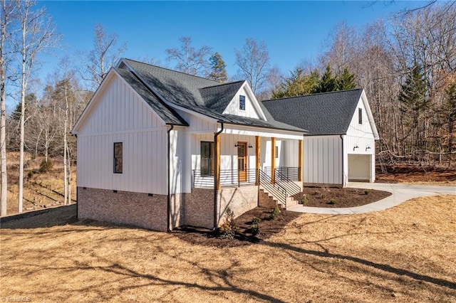 view of front of house with a garage, driveway, roof with shingles, a porch, and board and batten siding