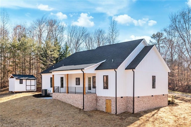 modern inspired farmhouse featuring covered porch, a shed, an outdoor structure, and cooling unit