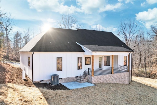 view of front of home featuring roof with shingles, central air condition unit, covered porch, board and batten siding, and crawl space