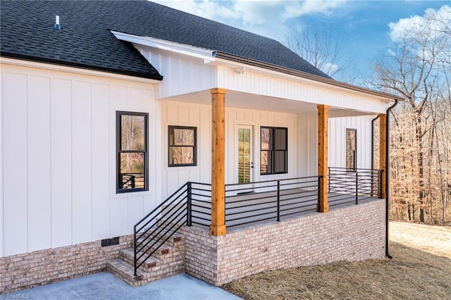 doorway to property featuring crawl space, covered porch, a shingled roof, and board and batten siding