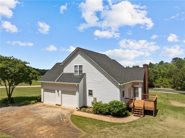 view of side of property featuring a garage, a yard, and a wooden deck