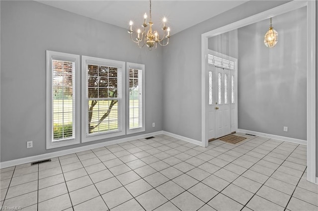 tiled entrance foyer with an inviting chandelier