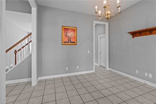 spare room with light tile patterned flooring and an inviting chandelier