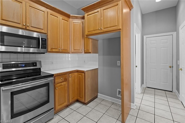 kitchen featuring light tile patterned floors, backsplash, and stainless steel appliances