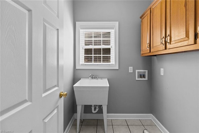 washroom featuring cabinets, hookup for a washing machine, and light tile patterned floors