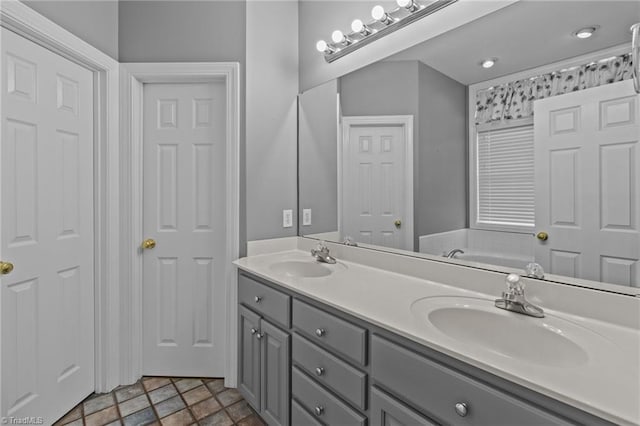 bathroom featuring a washtub and vanity