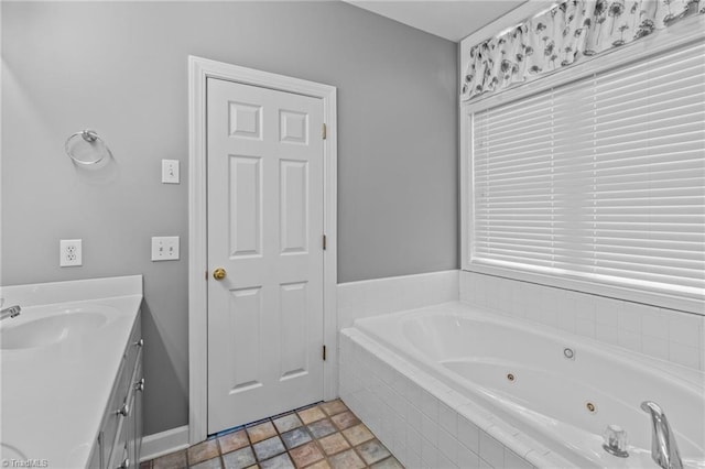 bathroom featuring vanity and tiled tub