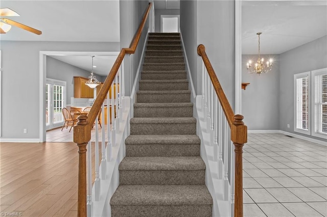 staircase with wood-type flooring and a chandelier