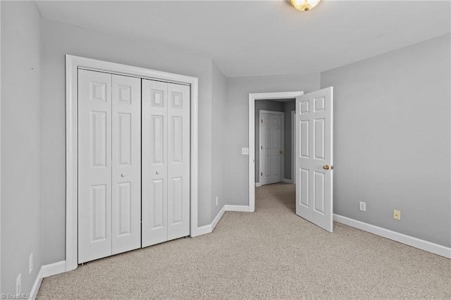 unfurnished bedroom with light carpet and a closet