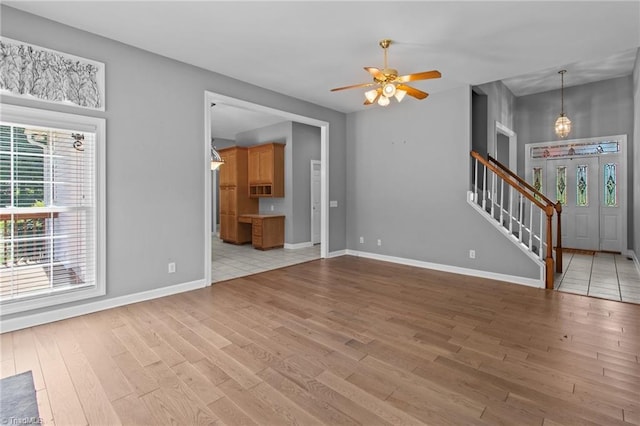 unfurnished living room featuring ceiling fan, plenty of natural light, and light wood-type flooring