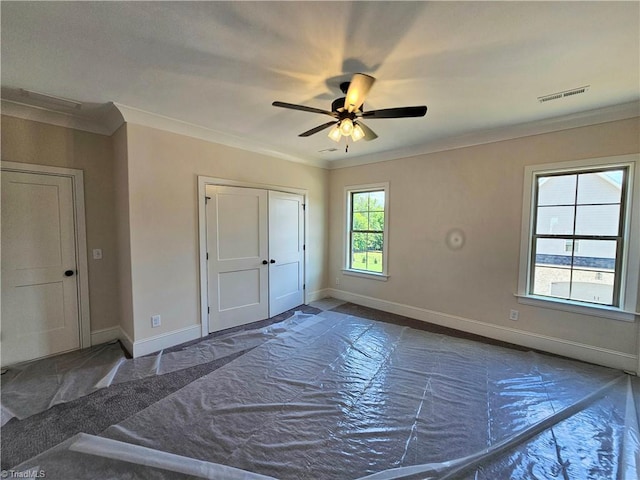 empty room with ceiling fan and crown molding