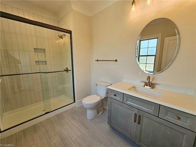 bathroom with vanity, toilet, and a shower with shower door