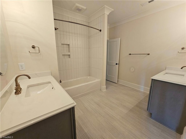 bathroom featuring vanity, tiled shower / bath combo, and ornamental molding