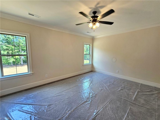 spare room featuring plenty of natural light, ornamental molding, and ceiling fan