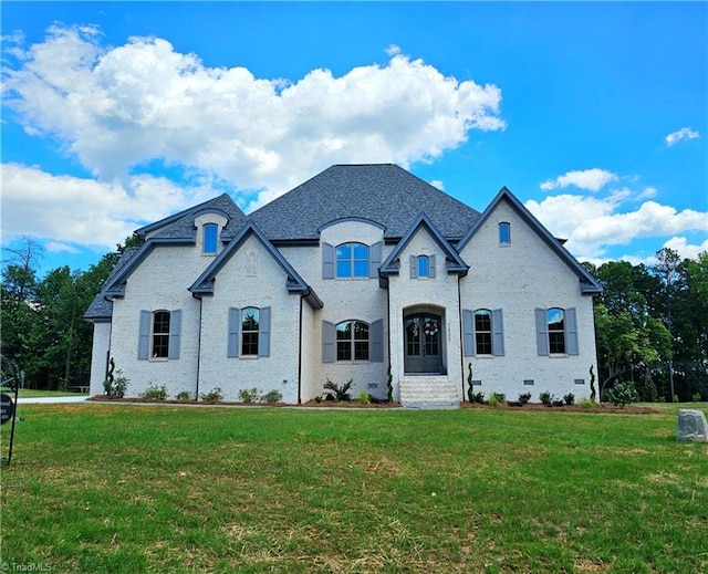 french provincial home with a front yard