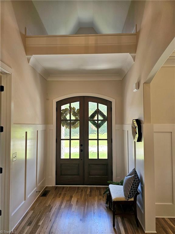 doorway featuring french doors, dark wood-type flooring, and vaulted ceiling