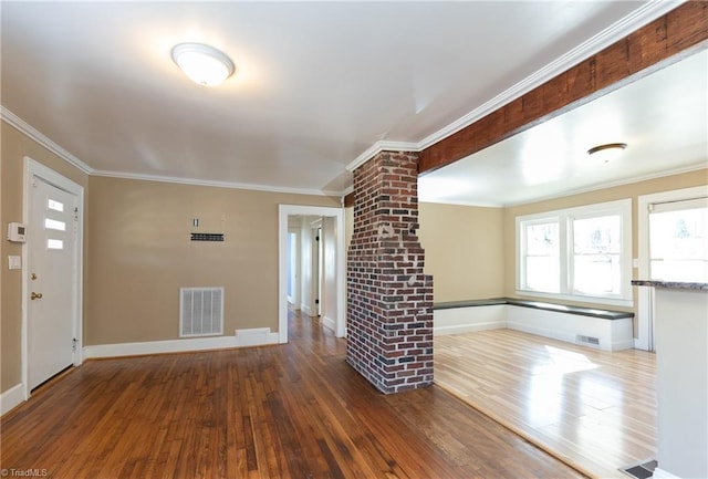 interior space featuring visible vents, crown molding, decorative columns, and wood finished floors