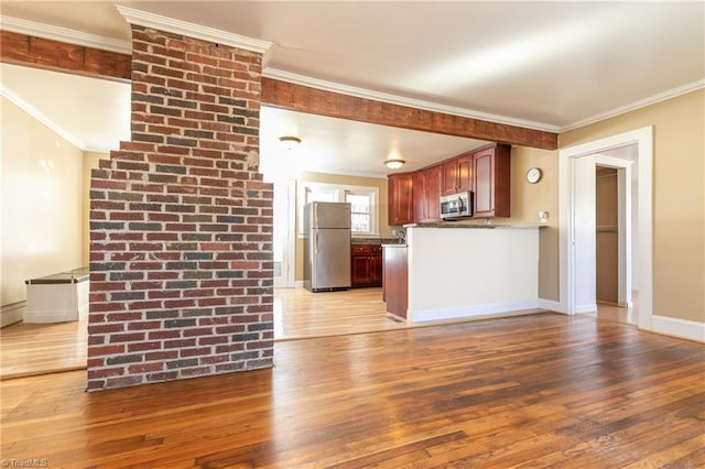 kitchen with ornamental molding, appliances with stainless steel finishes, and light wood-type flooring