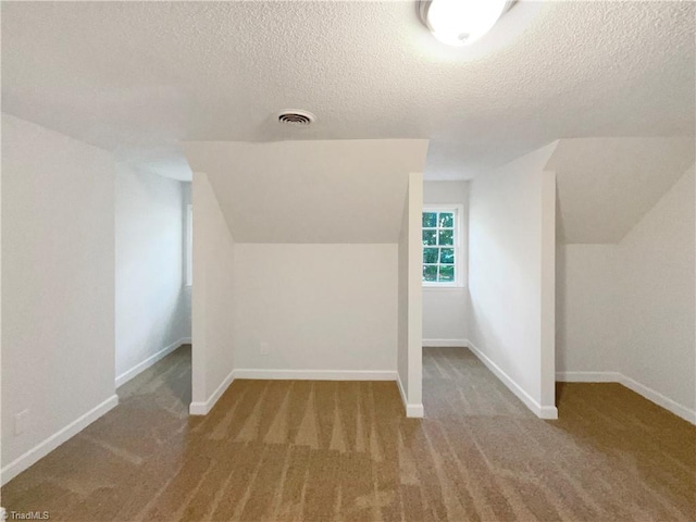 5605 Southstone Dr, Greensboro, NC 27406 - bonus room with a textured ceiling, carpet floors, lofted ceiling, and baseboards