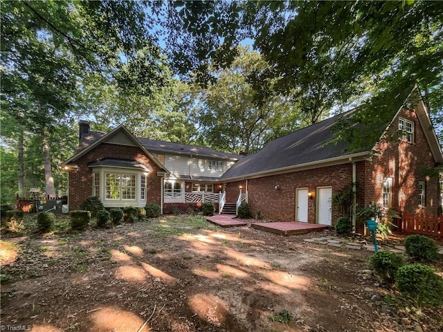5605 Southstone Dr, Greensboro, NC 27406 - view of front of house featuring brick siding, a wooden deck, and a chimney