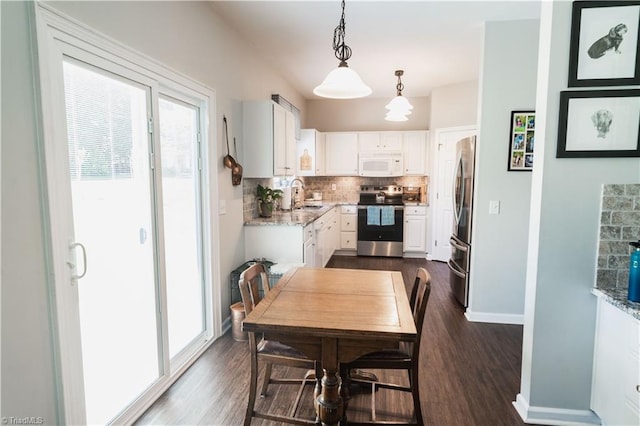 dining area with baseboards, dark wood-type flooring, and healthy amount of natural light
