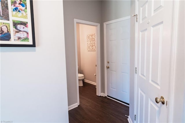 hall featuring baseboards and dark wood finished floors