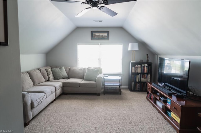 carpeted living area with a ceiling fan and vaulted ceiling