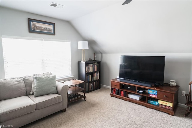 carpeted living area with vaulted ceiling and baseboards