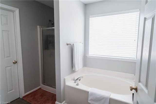 bathroom with a stall shower, a bath, and plenty of natural light