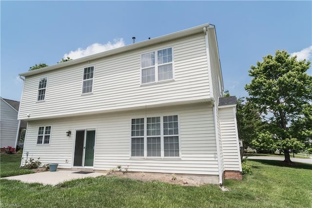 back of house with a yard and a patio