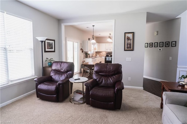 living area featuring carpet and baseboards