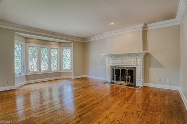 unfurnished living room featuring ornamental molding and hardwood / wood-style floors