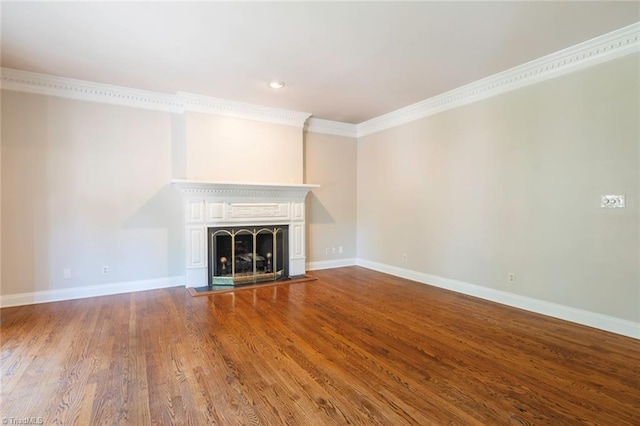 unfurnished living room featuring a fireplace, wood finished floors, crown molding, and baseboards