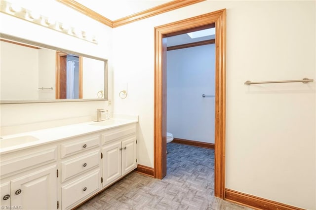 bathroom featuring vanity, crown molding, toilet, and parquet floors