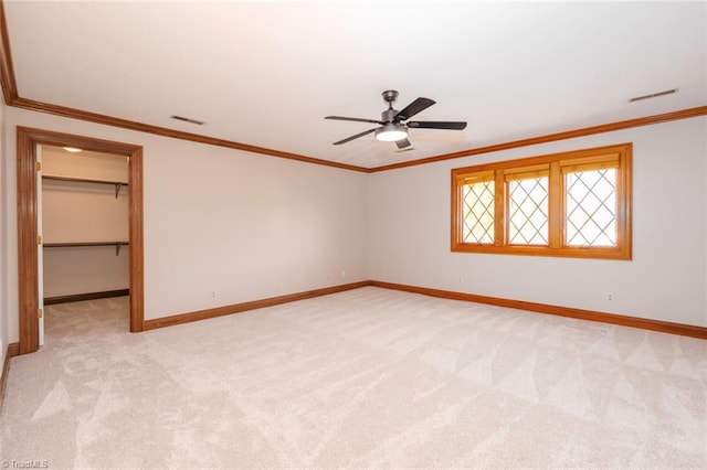 unfurnished room featuring ceiling fan, light colored carpet, and crown molding