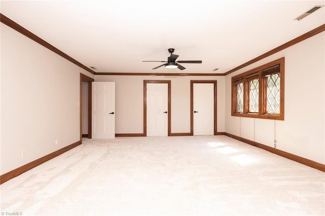interior space featuring visible vents, a ceiling fan, baseboards, and ornamental molding