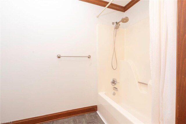 bathroom with shower / tub combo and baseboards