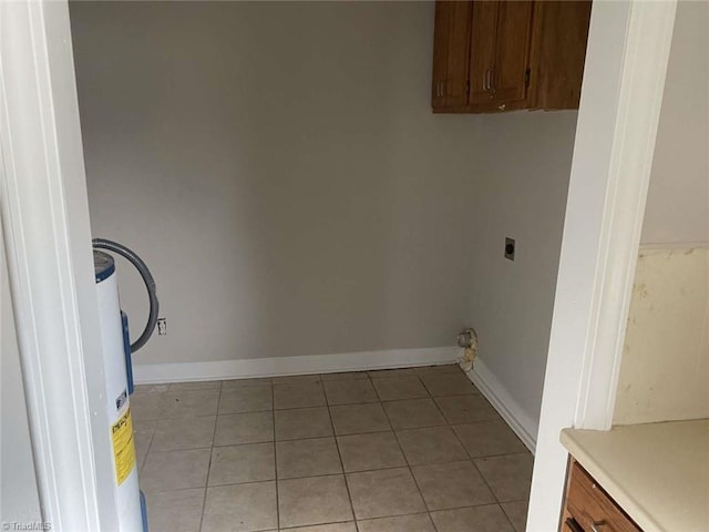 clothes washing area with cabinets, light tile patterned floors, and hookup for an electric dryer