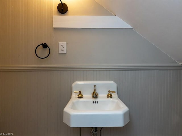 bathroom with wood walls and sink